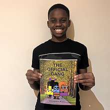 Young author Chikamso Kanu holds up a copy of his book, The Official Gang