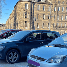 cars parked on pavement in Edinburgh