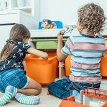 Two kids playing with toys and colourful boxes indoors by Kindel Media
