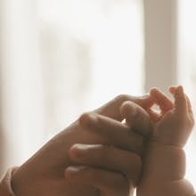 Close-up of an adult holding a baby's hand by Alexander Mass