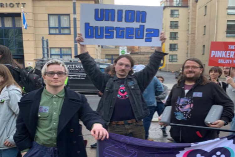 Protesters outside Rockstar Games' Edinburgh office hold up 'union busted?' sign. Courtesy of The Edinburgh Reporter.