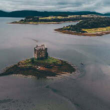 Stunning drone view of Castle Stalker on a small islet in Loch Laich, Scotland.