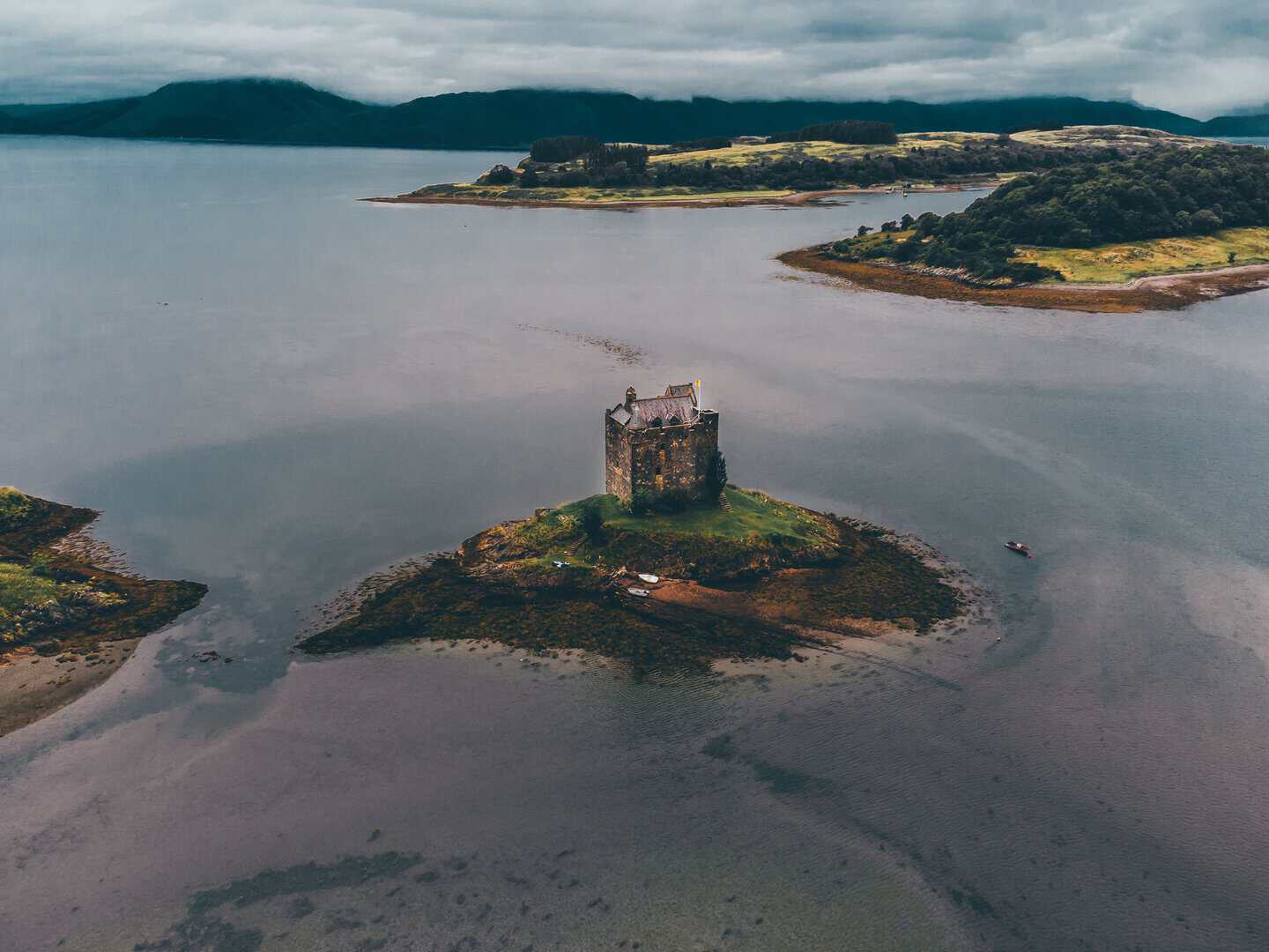Stunning drone view of Castle Stalker on a small islet in Loch Laich, Scotland.